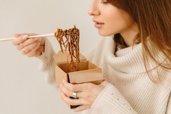 woman eating instant noodles