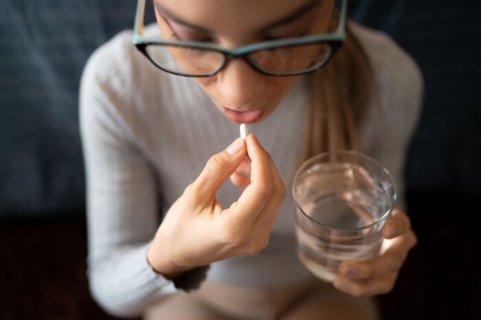 young woman taking paracetamol