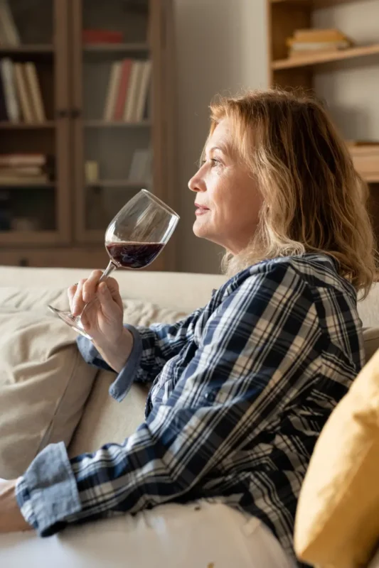 mature woman drinking non alcoholic wine at home