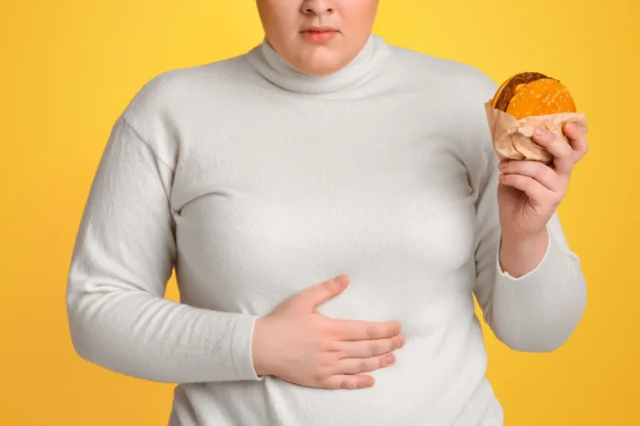 overweight teenager holding a burger